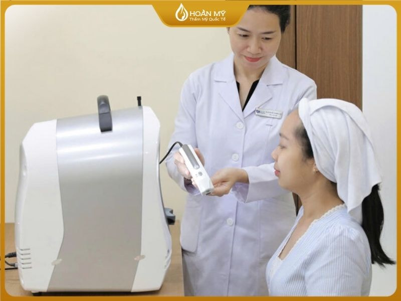 Khách hàng đang được bác sĩ thăm khám và soi da chuyên sâu tại Hoàn Mỹ