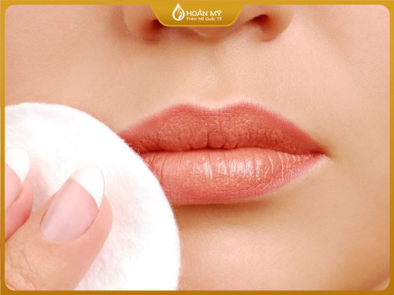 Dùng bông tẩy trang để lau môi